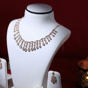 a white mannequin with a necklace and earrings on it