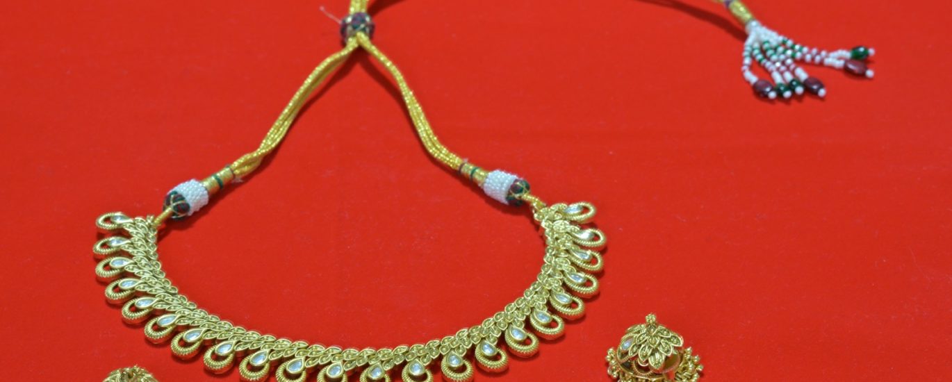 A necklace and earrings on a red surface