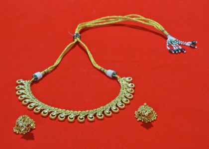 A necklace and earrings on a red surface