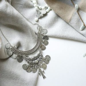 a close up of a necklace on a white surface