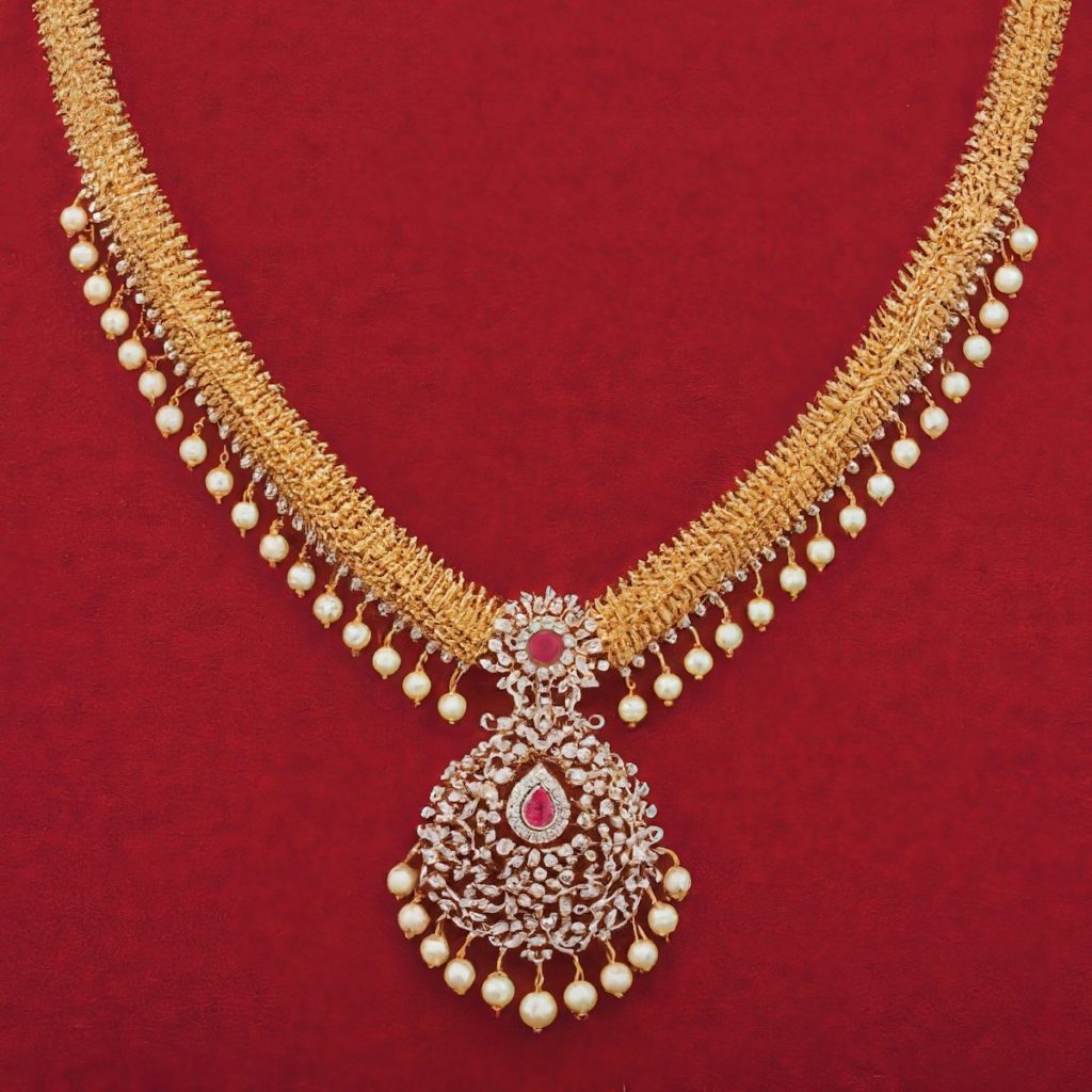 A gold necklace with pearls on a red background